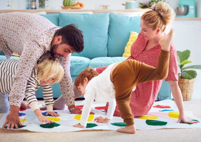 les parents et les enfants jouent au Twister en famille
