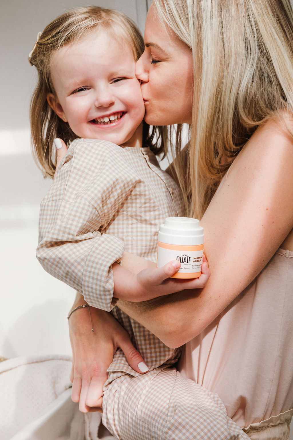 La maman embrasse sa fille, marque de produits pour enfants OUATE